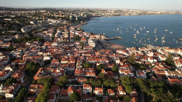 Drone aerial view of historic centre of Cascais, Portugal and Ribeira beach on a summer day