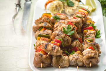 Arabic cuisine; Traditional grilled chicken Shish Kebabs or Shish Tawook on skewers. Close up with copy space. 