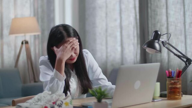 Asian Female Footwear Designer Having A Headache While Working On A Laptop At Home

