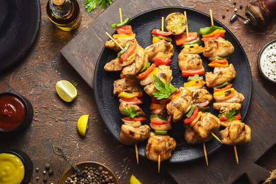 Arabic cuisine; Traditional grilled chicken Shish Kebabs or Shish Tawook on skewers. Close up with copy space. 