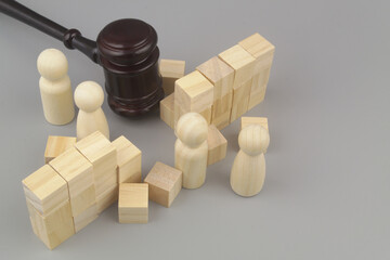 Wooden gavel breaking wall. and people figures on gray background Laws for people freedom concept.