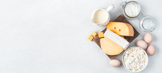 A set of dairy products and chicken eggs on a gray background. Top view, copy space