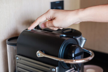 Hand making Espresso by Coffee Machine with capsules on wood table