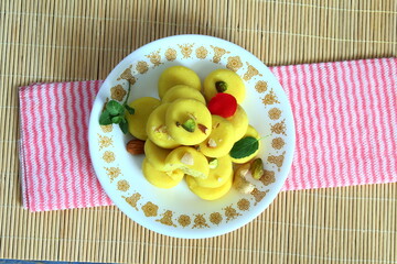 indian gujarati traditional sweet or mithai penda in dish with dry fruit garnish