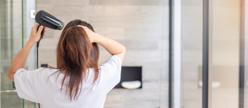 Young Woman Using Hair Dryer At Home Or Hotel. Hairstyles And Lifestyle Concepts