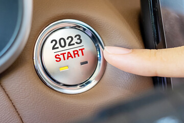 Finger press a car ignition button with 2023 START text inside  automobile. New Year New You,...