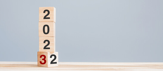 2022 chang to 2023 wooden cube blocks on table background. Resolution, plan, review, goal, start,...