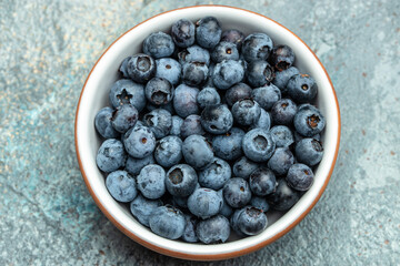fresh ripe blueberries in bowl on table close up. banner, menu, recipe place for text, top view