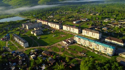 An urban-type settlement in the early morning at sunrise. A rural settlement located among hills with forests. Jewish Autonomous Region, the village of Kuldur in the Far East of Russia. 