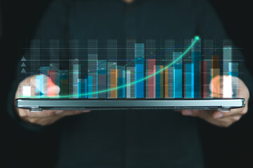 Concept graph of business growing, people holding laptop with monitor growing graph, stock graph and growing business marketing. 