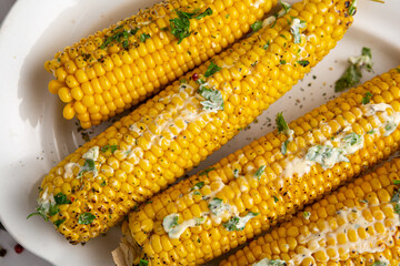 Sweet corn cobs with butter and greens grilled food top view