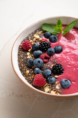Close up of acai smoothie bowl with chia seeds ad berries vegan food