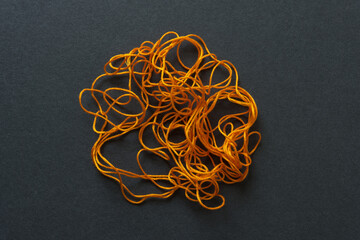 orange floss in a tangle on a gray board