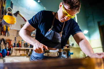 Carpenter young working with wood in workshop