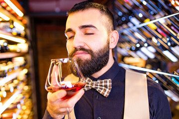 Authentic people arabian man sommelier appreciating drink in lux hotel