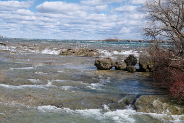The restless Niagara River and seagulls sitting on rocks
