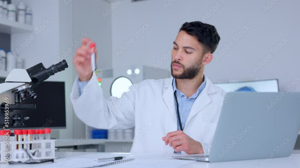Poster biologist working with blood collection tubes data and typing information on a laptop. one young mal