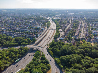 Aerial view of the waterworks roundabout in the morning sun looking east down the A406 into Woodford with cars driving down the dual carriageway - obrazy, fototapety, plakaty