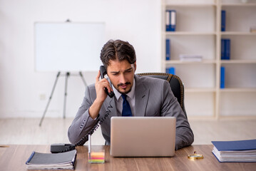 Young male employee sitting in the office