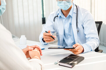 Doctors and patients sit and talk to the patient about medication in the hospital.