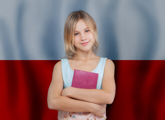 Beautiful smiling teen girl with book against flag of Poland background