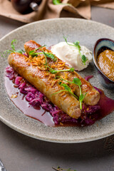 fried pork sausages on plate with sauce and coleslaw on brown table macro close up