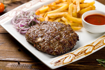 beef steak, beef patty with french fries and tomato sauce on old wooden table