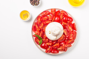 Burrata cheese salad with tomatoes, olive oil and seasoning. Fresh food concept. 