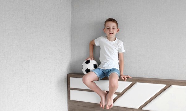 boy holding soccer ball in his hands, boy in a white t-shirt holding soccer ball in his hands on a light background, the concept of football and the soccer championship, the world cup, copy space