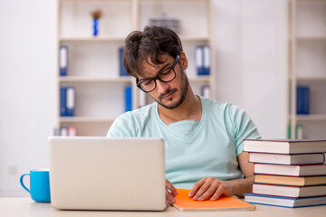 Young male student preparing for exams in the classroom