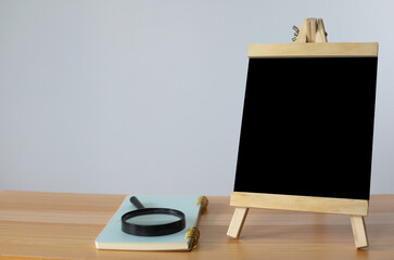Fototapeta premium small black board on wooden table,blank blackboard isolated