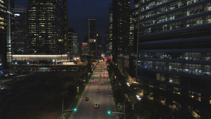 Top view of street with cars and modern buildings in big Chinese city at night. Shot. Night aerial...