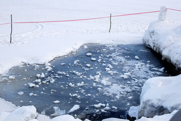 Melting of ice on the reservoir. Thin Ice warning sign. A sign warns of danger as ice thaws