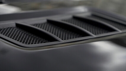 Close up for detail of air vents on the bonnet of a modern black car. Stock. Car exterior...