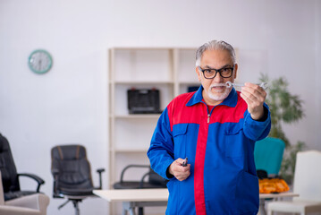 Old male repairman working at workshop