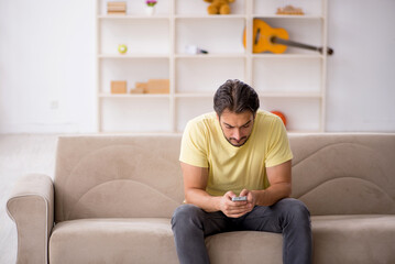 Fototapeta premium Young man sitting at home during pandemic