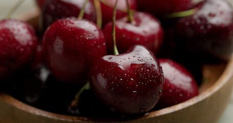 red cherries in a basket on a green wooden table