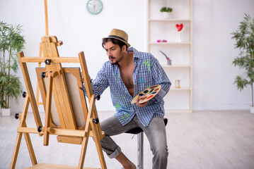 Young man enjoying painting at the studio