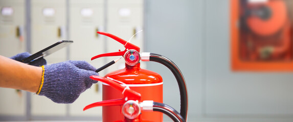 Fire extinguisher has hand engineer inspection checking pressure gauges to prepare fire equipment...