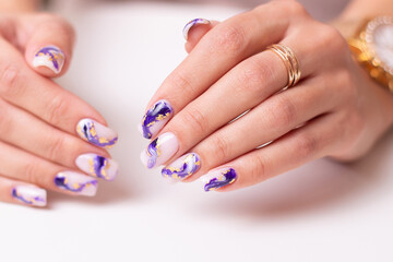 Beautiful female hands with luxury manicure nails, purple gel polish