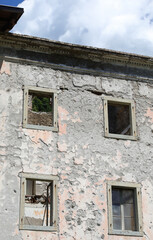 windows without the frames of a completely destroyed house without the roof and abandoned