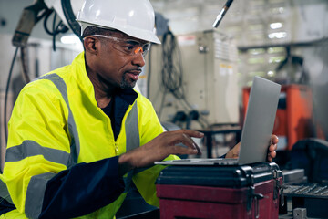 Factory worker working with laptop computer to do adept procedure checklist . Factory production line operator occupation quality control concept .
