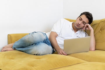 Young sleepy student studying online at home. Distance education concept