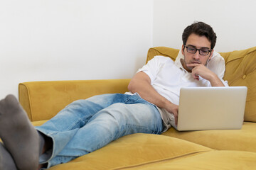 Young businessman working on laptop at home. Distant work concept