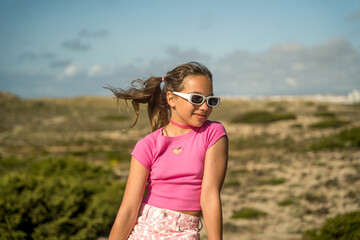 Child girl in vivid outfit standing at the street and looking away