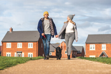 Happy couple walking the dog on a sunny autumn day - 518974146