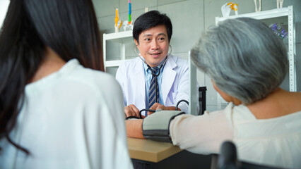 Fototapeta premium Male doctor measuring the patient's blood pressure Senior woman in the hospital.