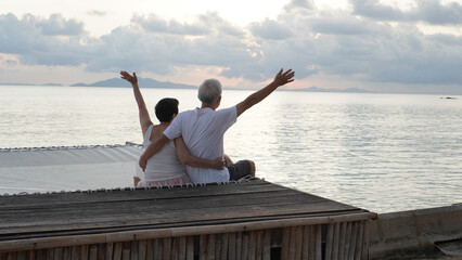 Fototapeta na wymiar Asian senior elder couple relax enjoy have fun on tropical seaside morning vacation retirement trip