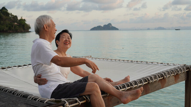 Asian senior elder couple relax enjoy have fun on tropical seaside morning vacation retirement trip