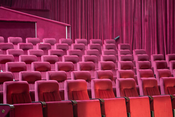 Empty red chairs for audience in the theater